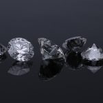 A row of loose diamonds photographed from closeup.